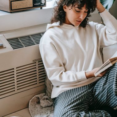 thoughtful woman reading book in living room