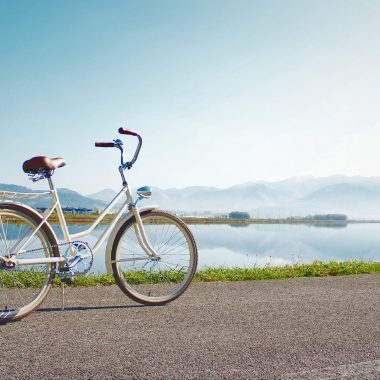 gray commuter bike parked on road beside sea