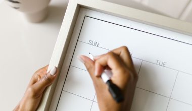 Iemand plant werkdagen op een wandkalender om twee banen te combineren